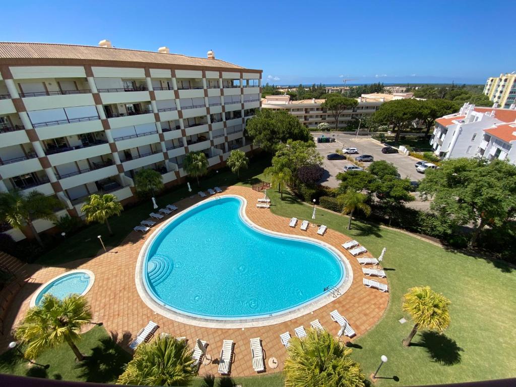 una vista aérea de una piscina frente a un edificio en Vilamoura Avelãs Ocean View Apartment en Vilamoura