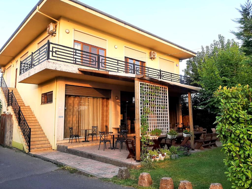 a yellow house with a balcony and a patio at Hotel Vila Giorgio in Shkodër