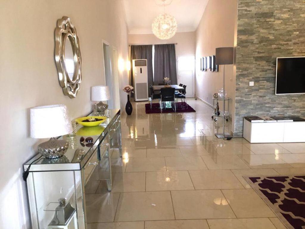 una gran sala de estar con un gran suelo de baldosa. en Stunning 3-Bed House in Tema-Ahenfie Villa en Kwedonu