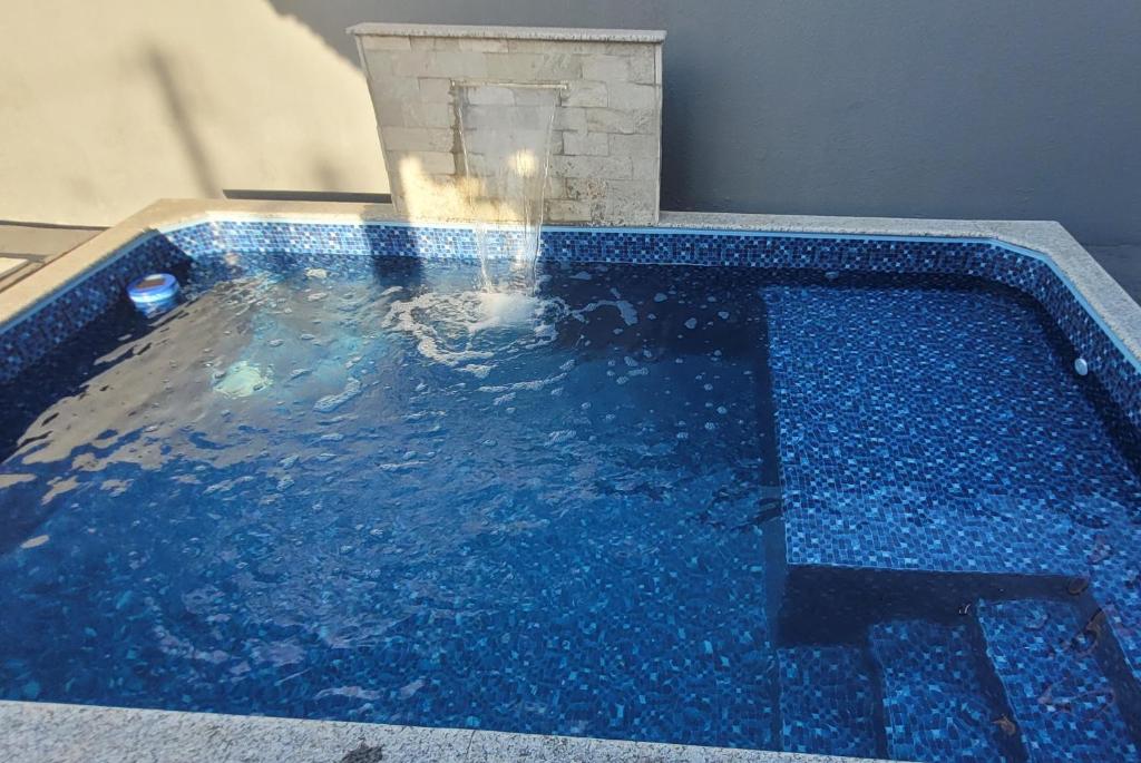 a swimming pool with blue water in a room at Casa em Caldas Novas in Caldas Novas