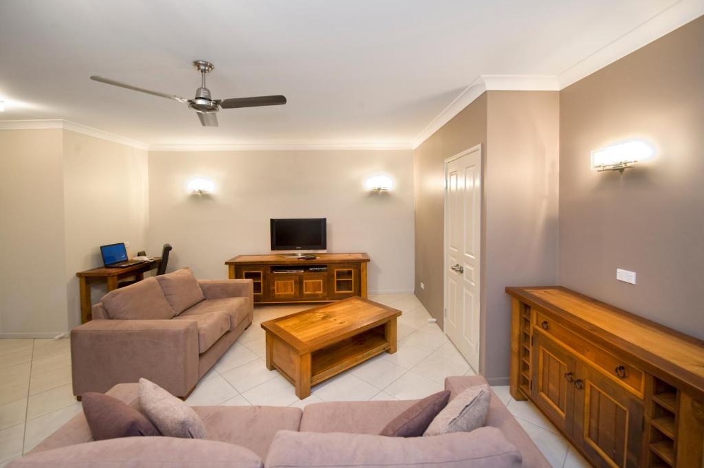 a living room with two couches and a tv at Apartments on Palmer in Rockhampton