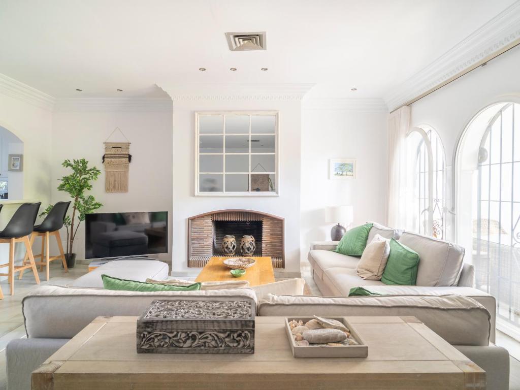 a living room with a couch and a fireplace at Gorgeous townhouse with shared pool in the middle of Marbella All yours in Marbella