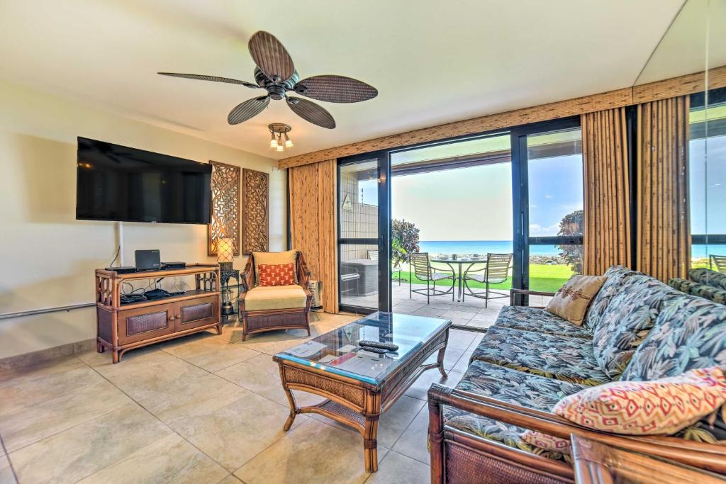 a living room with a couch and a tv at Beachfront Condo Sunset Views and Pool Access! in Kahana