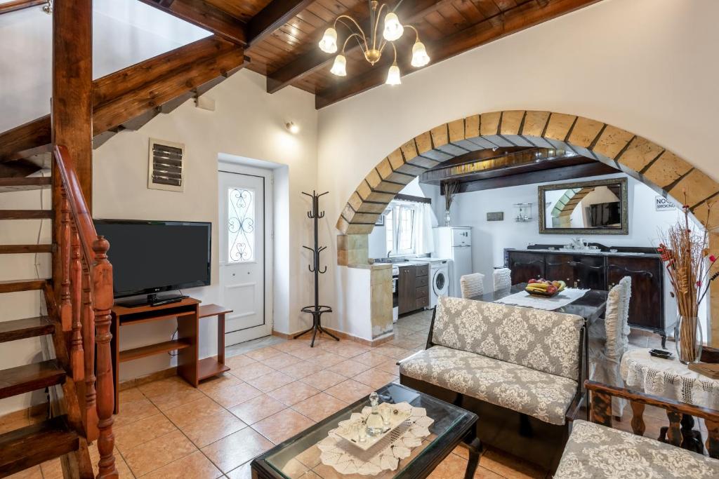 un soggiorno con divano e TV di Aroni Cretan comfortable house - Hamam suites Aroni a Arónion