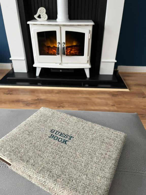 a rug on the floor in front of a fireplace at Marie's Hoose in Stornoway