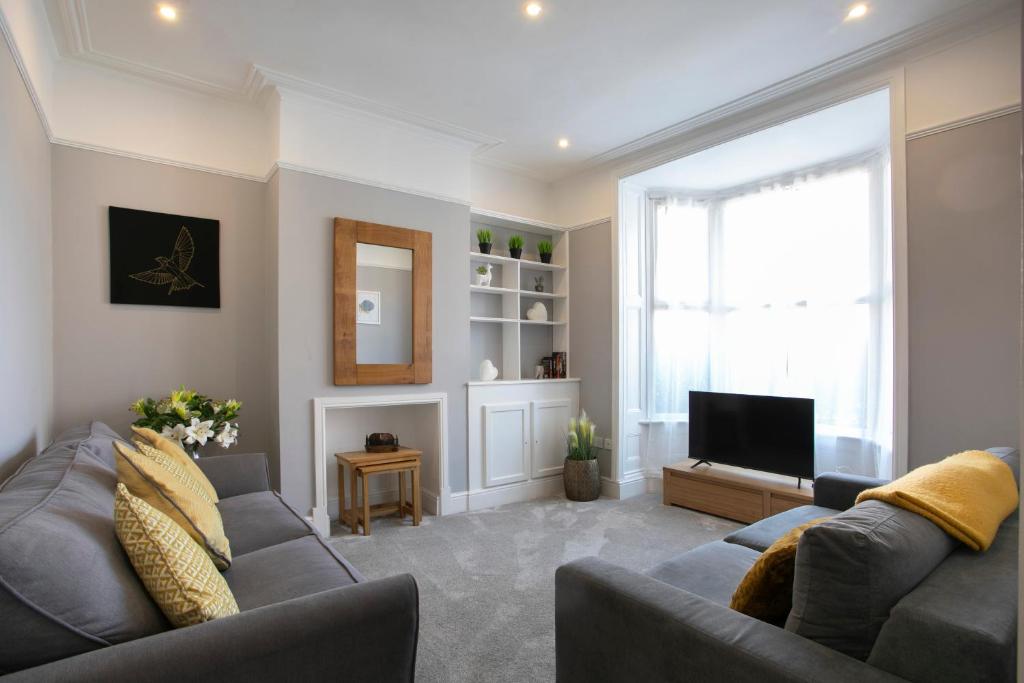 a living room with a couch and a television at Spring Villa in Leicester