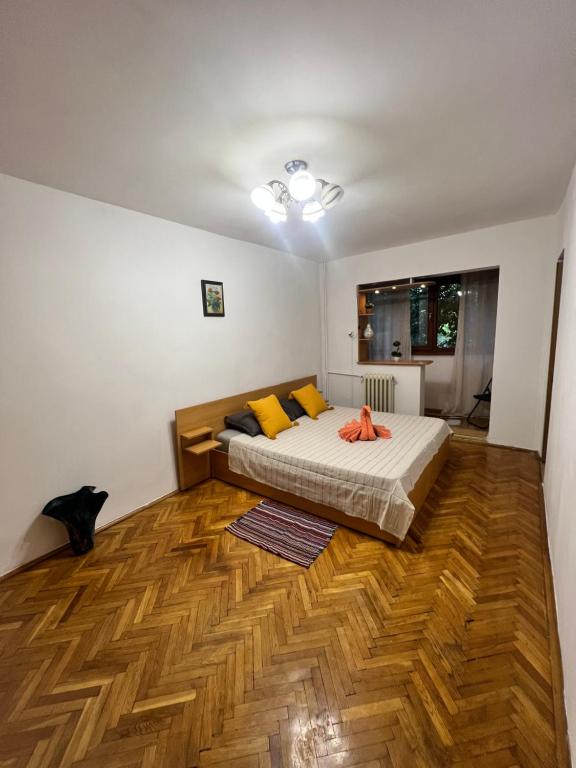 um quarto com uma cama e piso em madeira em Miha modern and central apartament Malul Mureșului em Arad