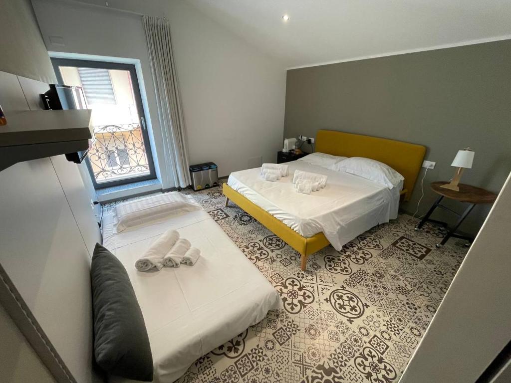pokój hotelowy z dwoma łóżkami i oknem w obiekcie Gaias Rooms w mieście Olbia