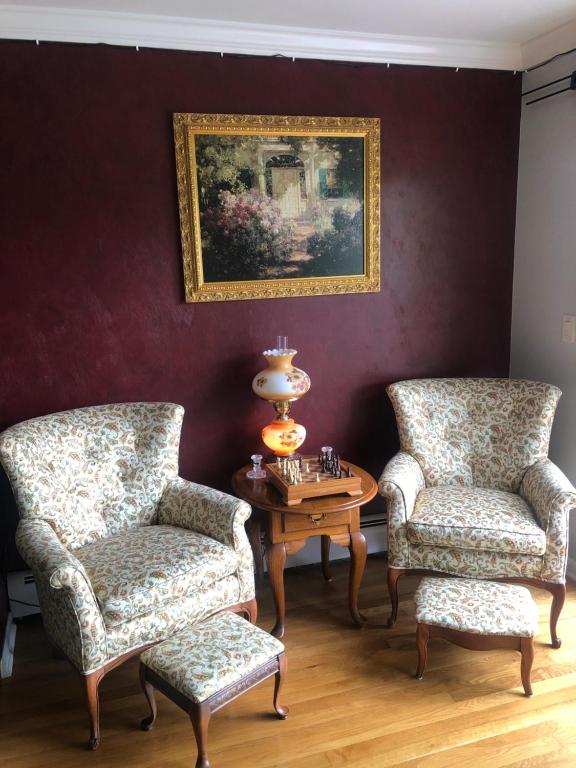 Pokój z dwoma krzesłami, stołem i obrazem w obiekcie The Fallen Tree Inn w mieście Geneva