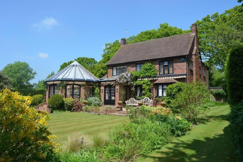 una vieja casa de ladrillo con un jardín delante de ella en Holmans NEW FOREST, en Burley