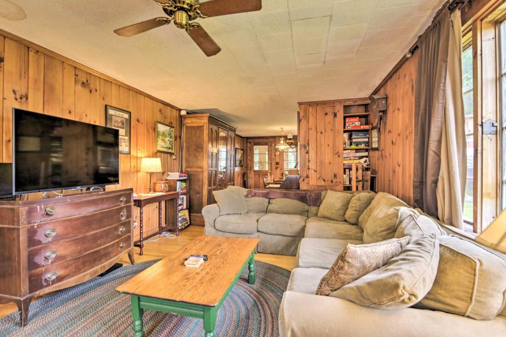 a living room with a couch and a tv at Rustic Roxbury Ski Farmhouse with Trails! in Roxbury