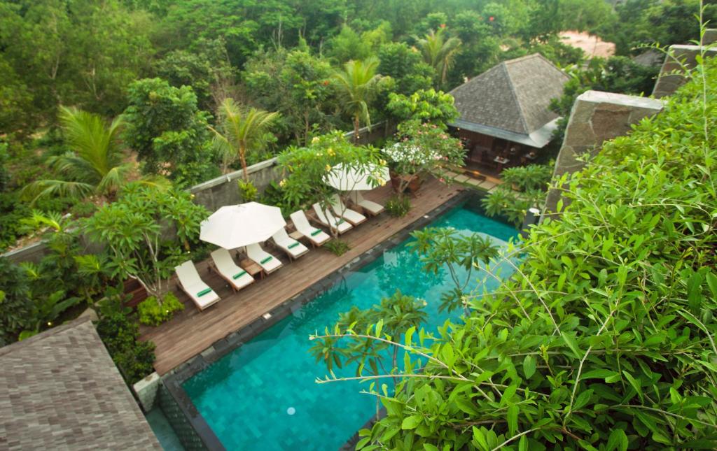 an aerial view of a pool with lounge chairs and a resort at The Astari Villa and Residence in Jimbaran