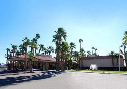 a building with palm trees in front of a street at Ramada by Wyndham Yuma in Yuma