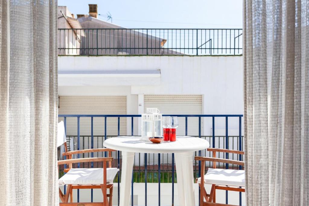 a white table on a balcony with chairs at LLAFRANC 100 - calle Coral- in Llafranc