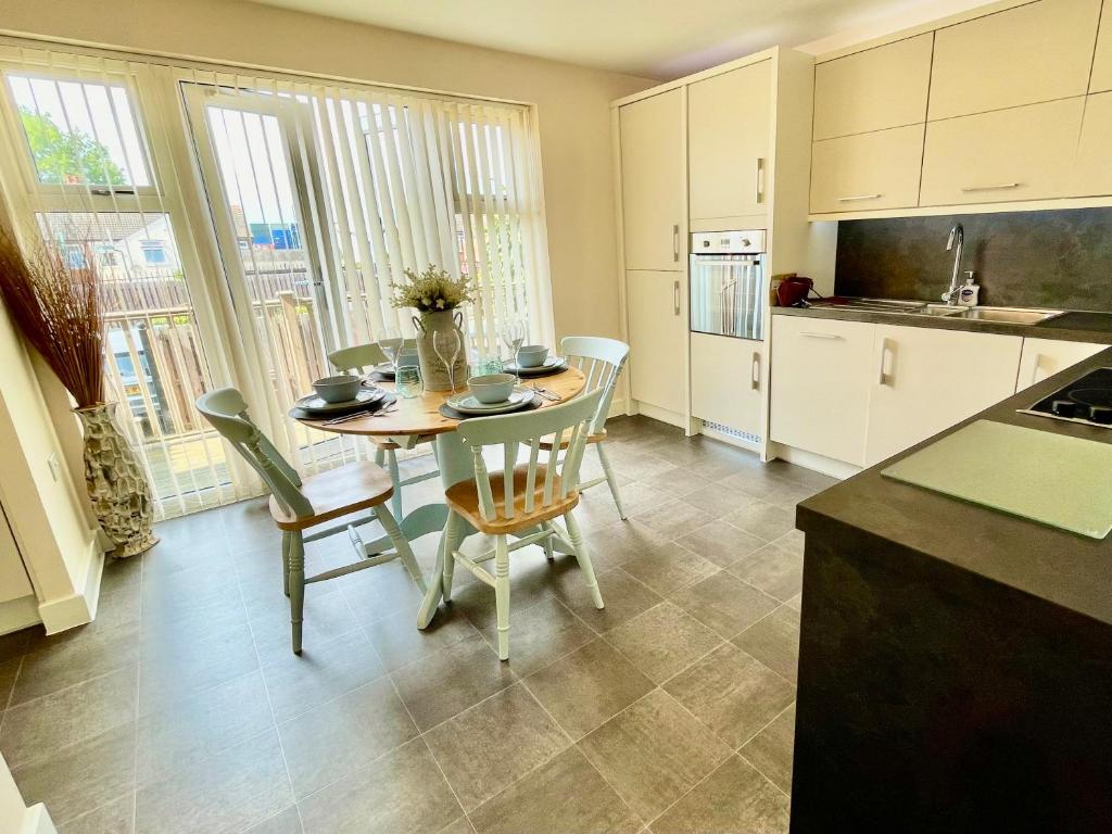 eine Küche und ein Esszimmer mit einem Tisch und Stühlen in der Unterkunft Luxurious Beach House with spectacular sea views in Felixstowe
