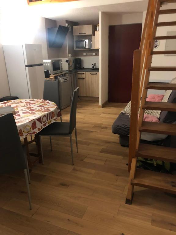 a kitchen and a dining room with a table and chairs at Appartement 3è étage à St-Marie-de-Campan in Sainte-Marie-de-Campan