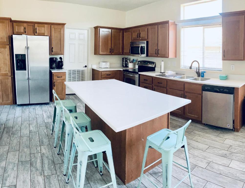 a kitchen with a large white counter top and wooden cabinets at HorseshoeBendHouse is Close to canyons Renovated recently with boat parking in Page