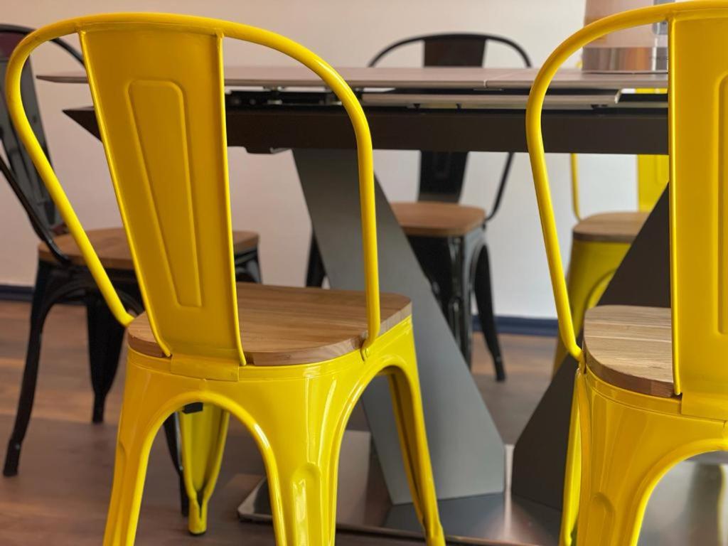 duas cadeiras amarelas sentadas ao lado de uma mesa em TQCaleta Providencia Barrio Italia em Santiago