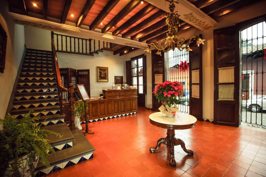 um lobby com uma mesa com flores em Meson del Alferez Coatepec em Coatepec