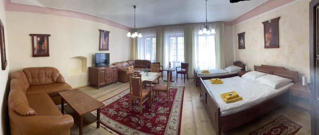 a bedroom with a bed and a living room with a couch at Pension Pod Radnicí in Český Krumlov
