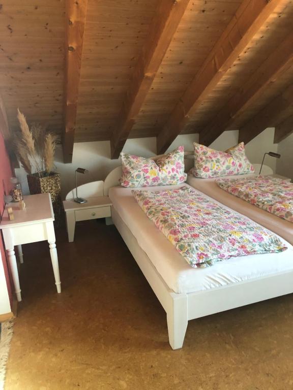a bedroom with two beds with pillows and a table at Haus Bergblick in Kißlegg