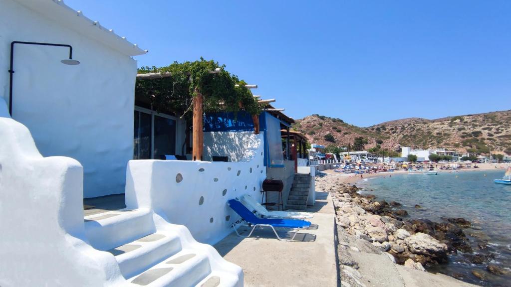 a blue chair sitting next to a beach at Stegna Rita's apartment in Archangelos