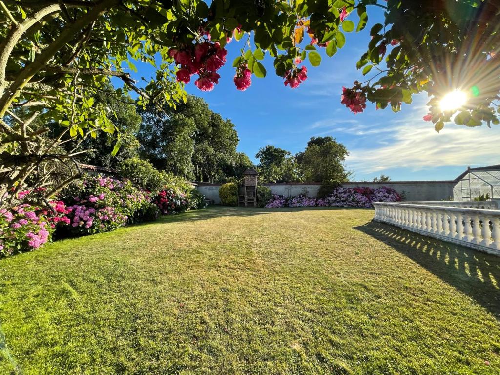 d'un jardin avec des fleurs et une clôture blanche. dans l'établissement Le Hâble 2 Paix - gîte rural en Baie de Somme, à Woignarue