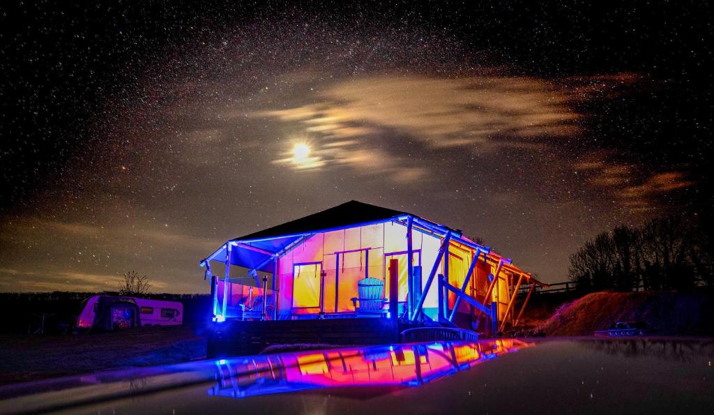 ein beleuchtetes Haus in der Nacht mit Sternenhimmel in der Unterkunft Semira Tent Lodge in Totnes