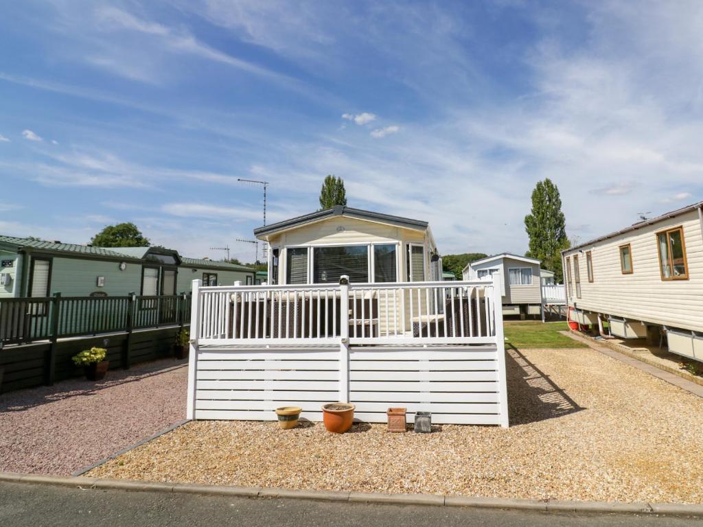 a white fence in front of a house at Poppy Lodge in Stratford-upon-Avon