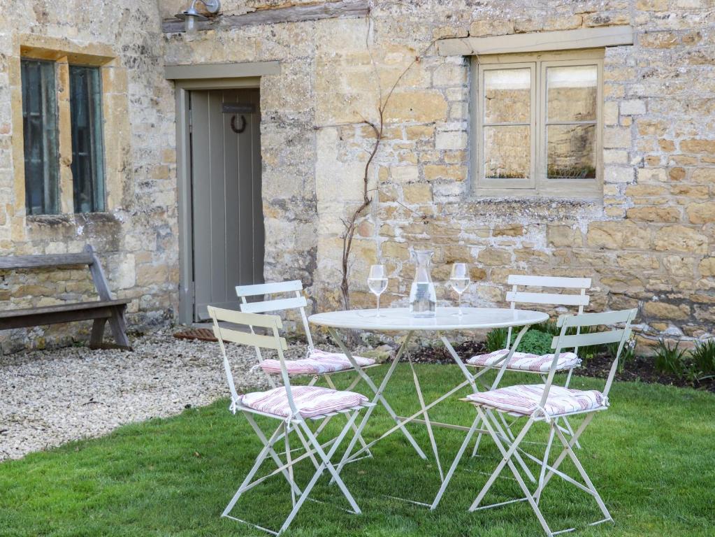 a table and chairs in front of a building at The Compton Cottage in Cheltenham