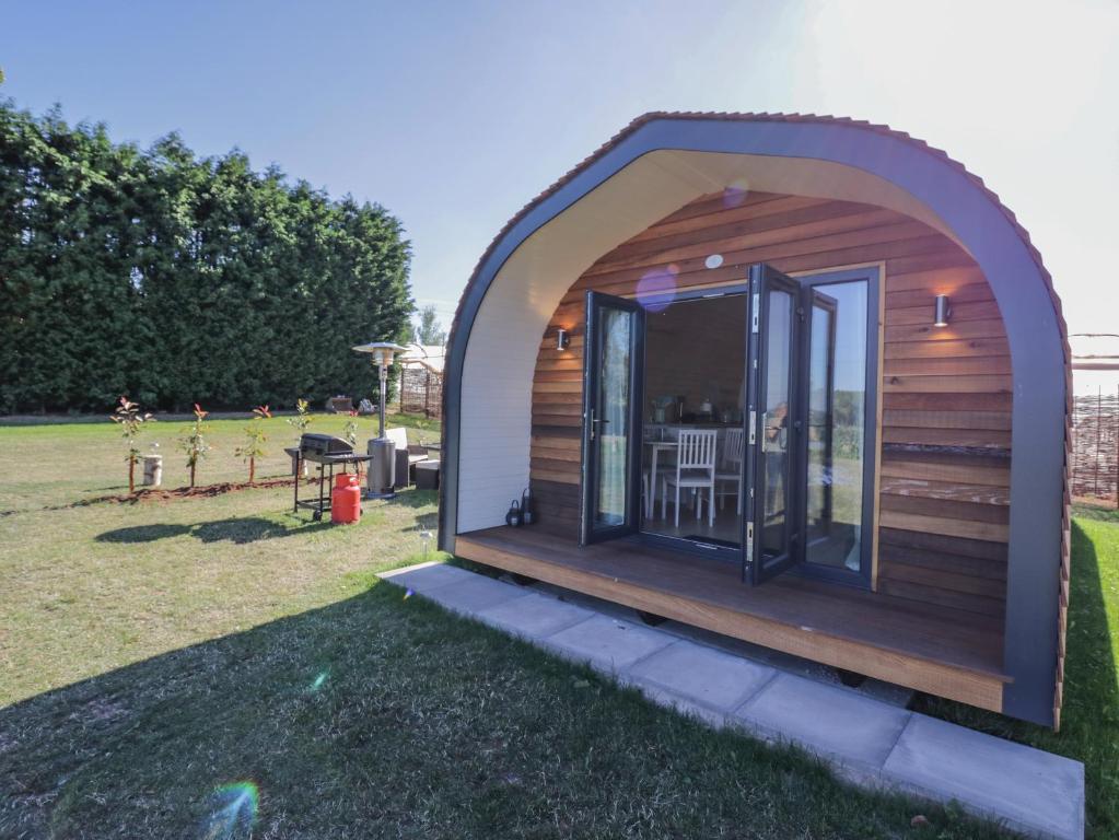 a small wooden cabin in a garden with a patio at Tamina in Worcester