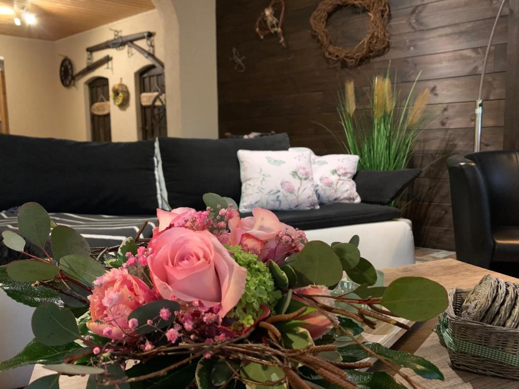 een woonkamer met een tafel met een boeket bloemen bij Inas Spreewaldstube in Vetschau