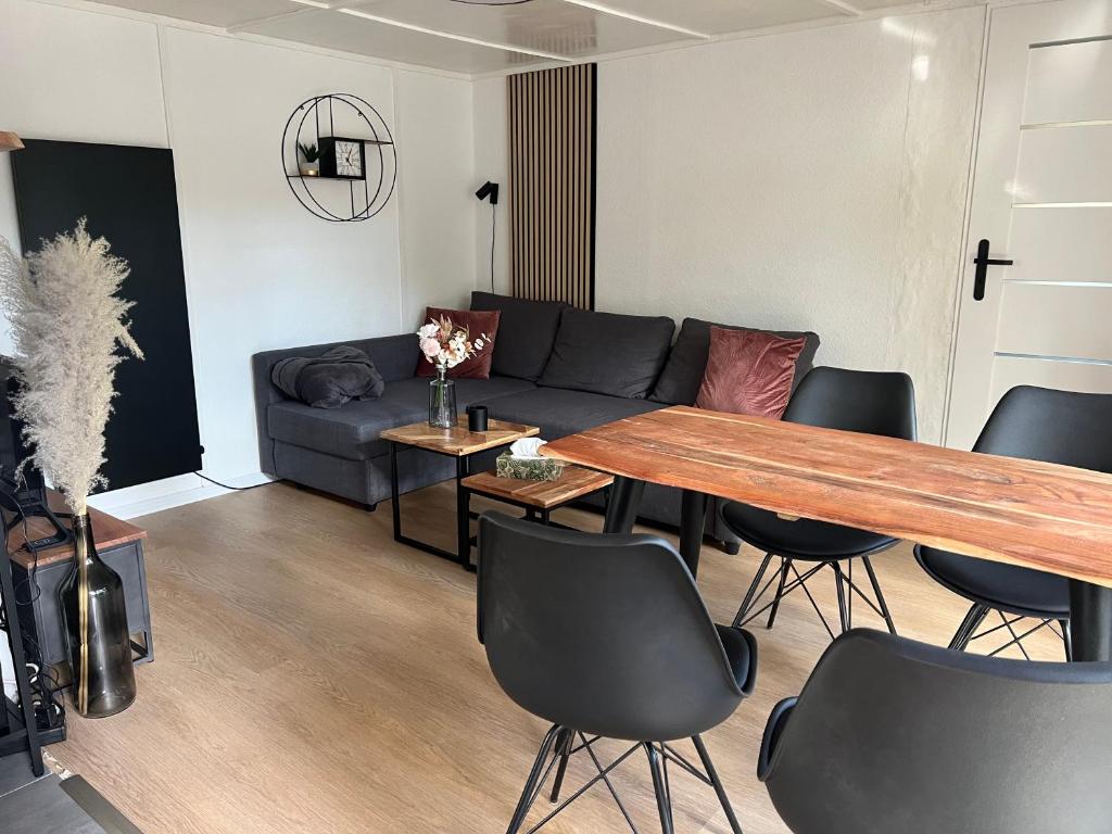 een woonkamer met een bank en een tafel en stoelen bij Idyllischer Bungalow am Badesee in Reuthen