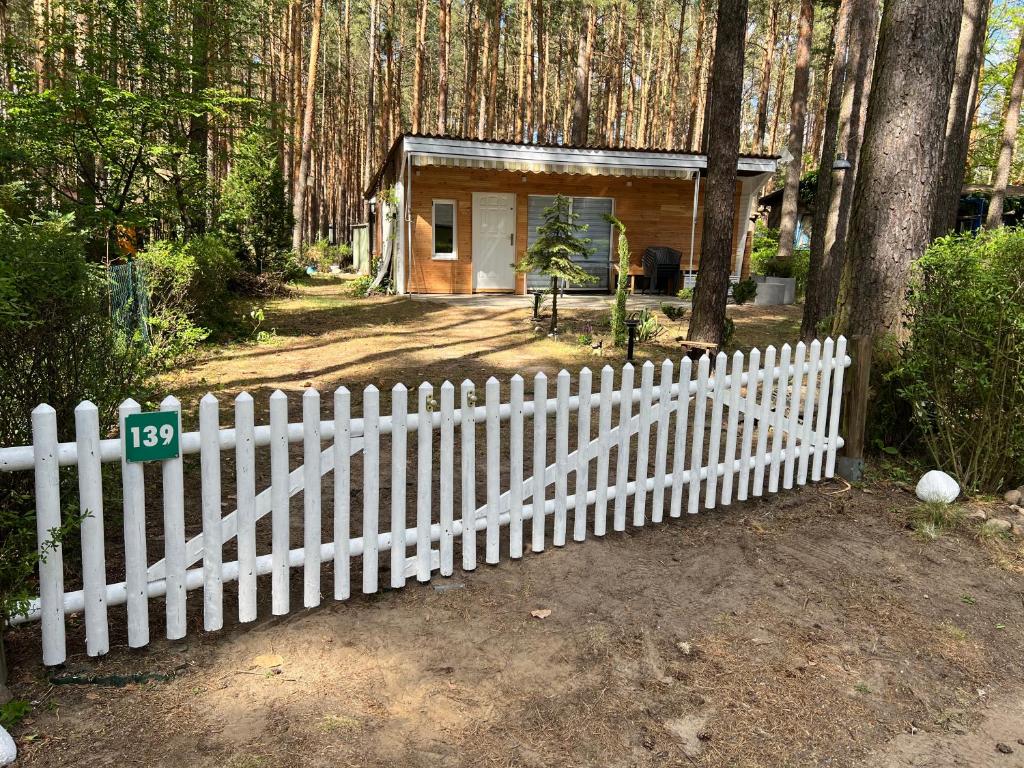 une clôture blanche devant une maison dans l'établissement Idyllischer Bungalow am Badesee, à Reuthen