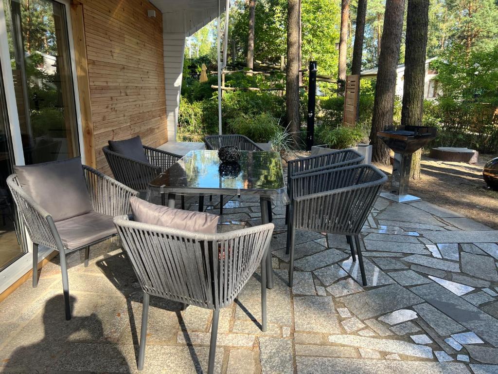 a patio with chairs and a table on a stone patio at Idyllischer Bungalow am Badesee in Reuthen