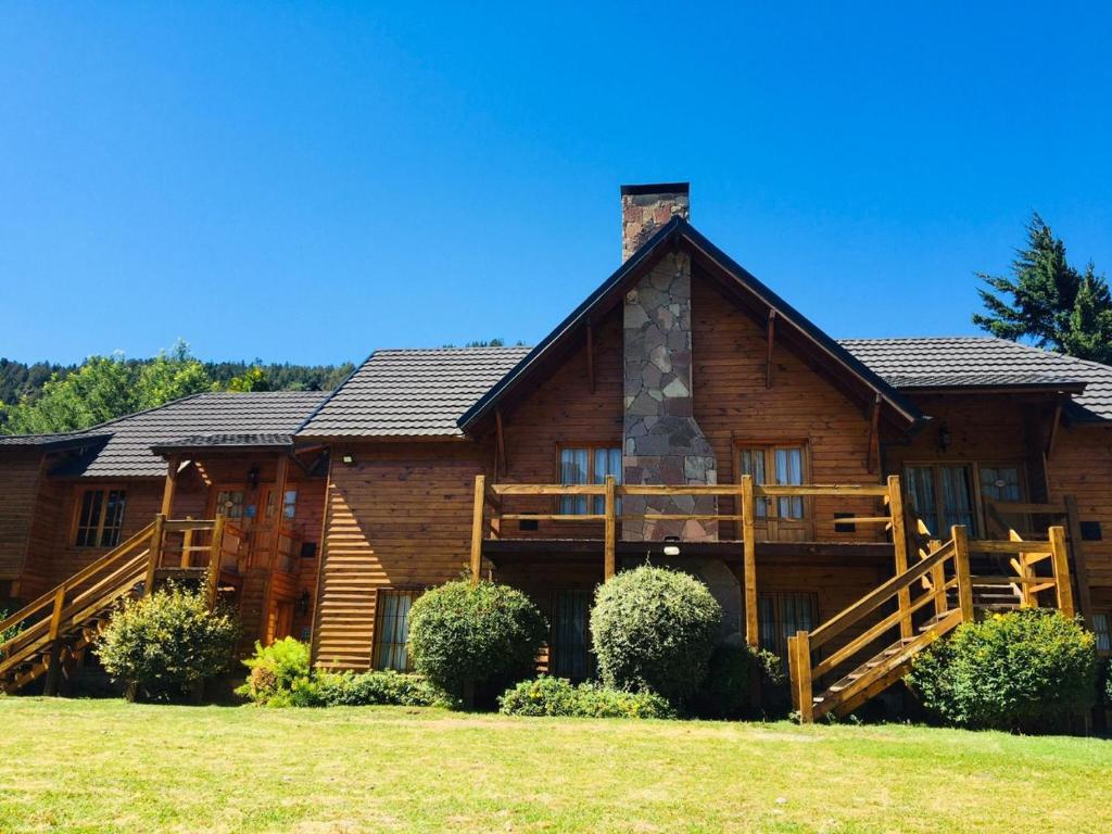 a log cabin with a porch and a yard at Cabañas Chapelco in San Martín de los Andes