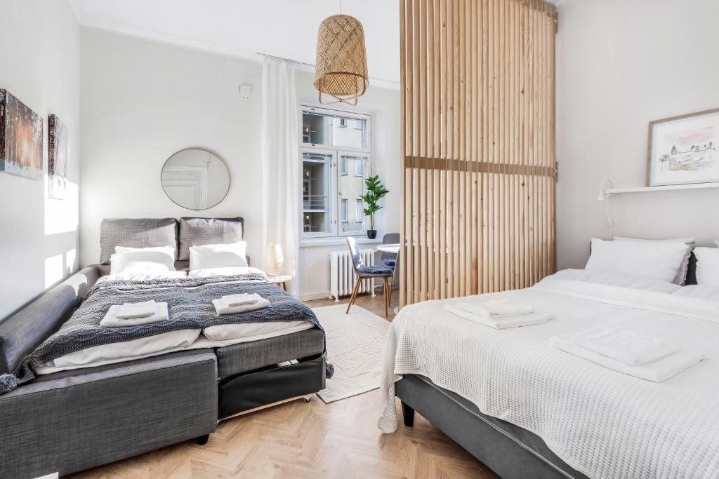 a bedroom with two beds and a dining room at WeHost Nordic Glamour nearby the Tervasaari Island in Helsinki