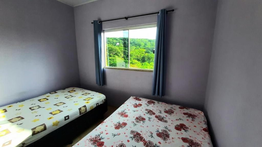 a bedroom with two beds and a window at Casa Santos - Pirenópolis in Pirenópolis