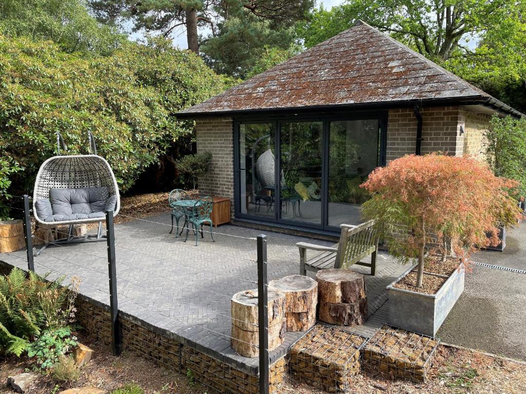 a pavilion with a bench and a chair in a garden at The Observatory Annexe in Dorking
