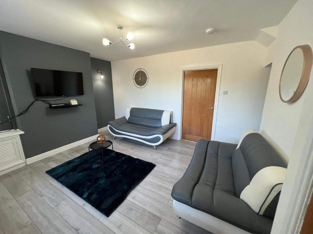 a living room with a couch and a television at Cosy, Modern Home Near BHX, NEC and City Centre in Birmingham