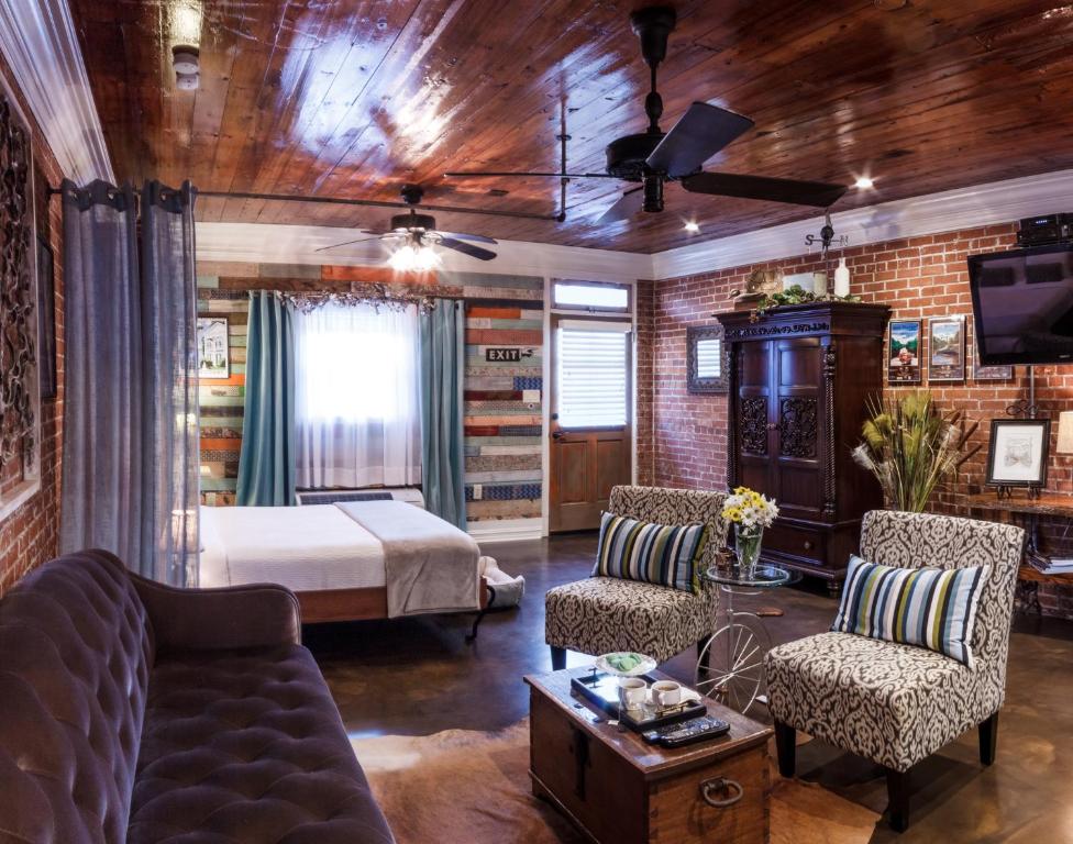 - un salon avec un lit, un canapé et des chaises dans l'établissement Bayou Chateau, à La Nouvelle-Ibérie