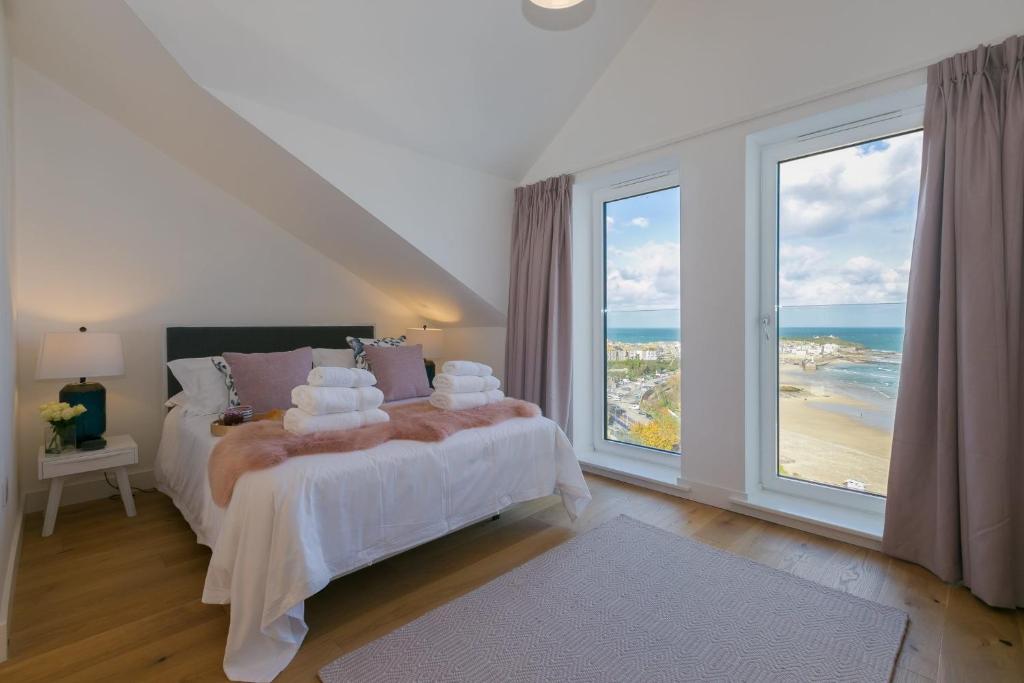 a bedroom with a bed with a view of the ocean at Beach View in St Ives
