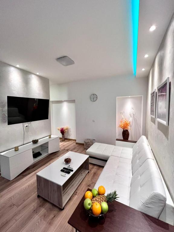 a living room with a white couch and a tv at Hugolina LUX in Belgrade