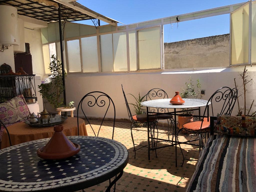 un patio con sillas y mesas y una gran ventana en Dar Lalla Wafae, en Fez