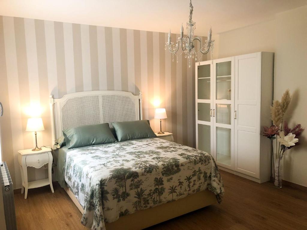 um quarto com uma cama, 2 candeeiros e um lustre em KIKU Apartments II em Bermeo