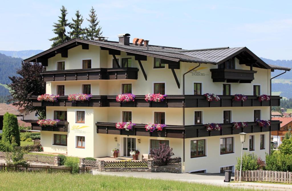 a large white building with flowers on the balconies at Hotel Garni Ingeborg in Westendorf