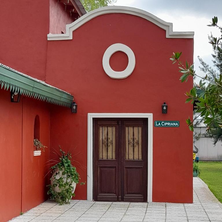 un edificio rojo con una puerta al frente en La Cipriana, en Concepción del Uruguay
