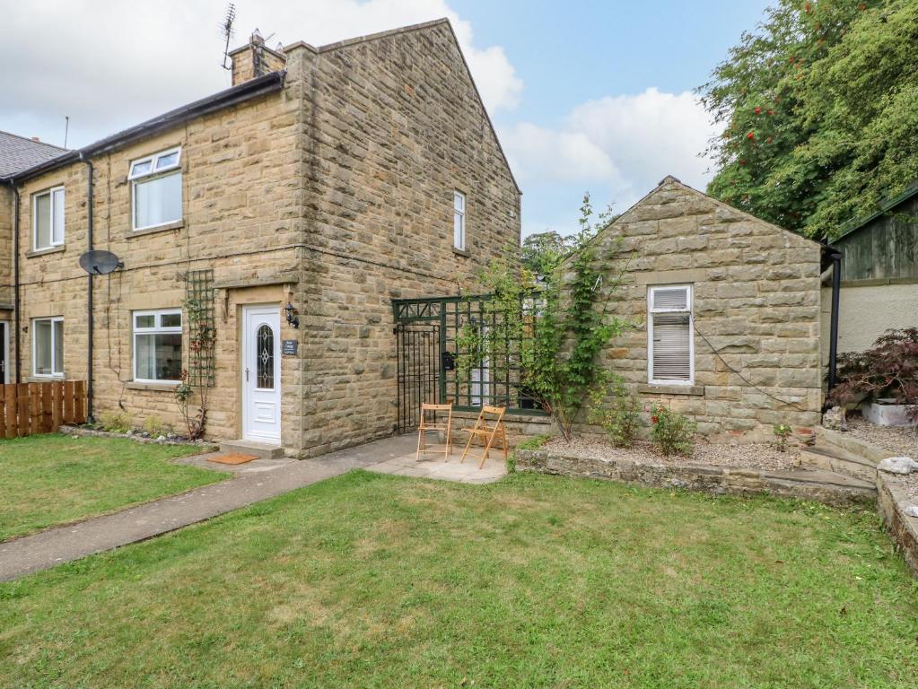 a stone house with a yard in front of it at Rose Cottage in Barnard Castle