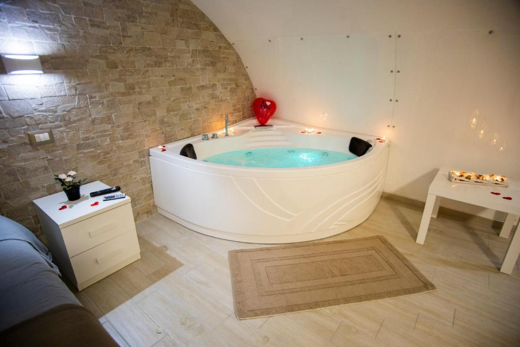 bañera grande en una habitación con mesa en Maison Gianluca, en Catania