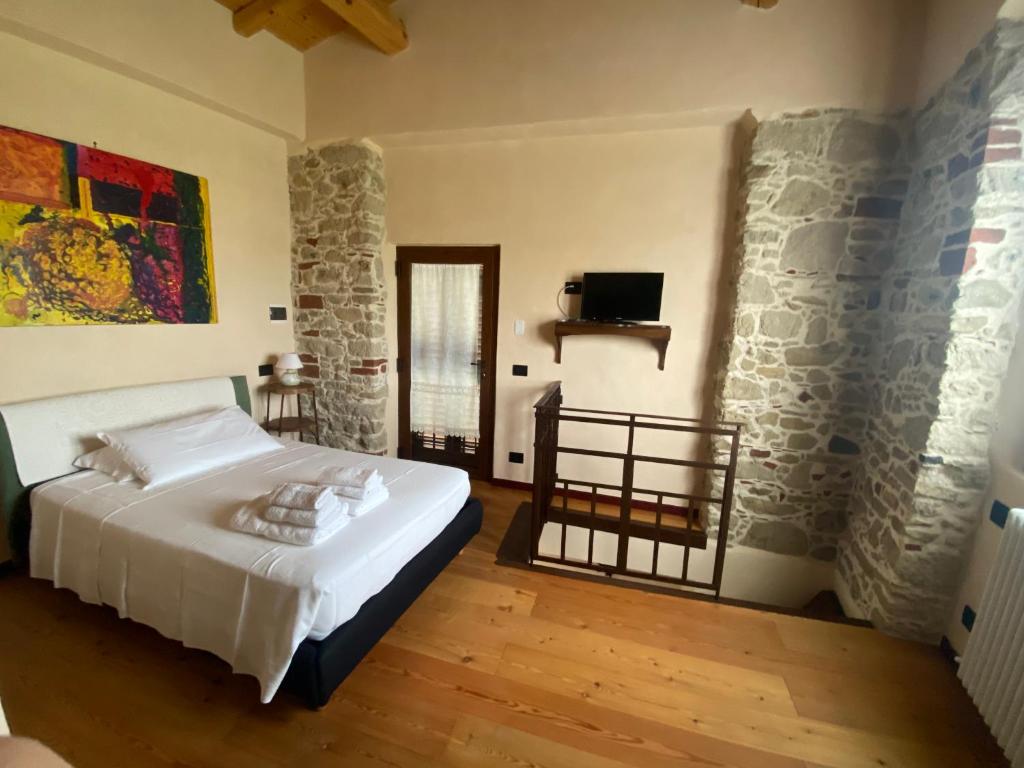 a bedroom with a bed and a stone wall at LOCAZIONE TURISTICA IL BRICCHETTO in Parodi Ligure